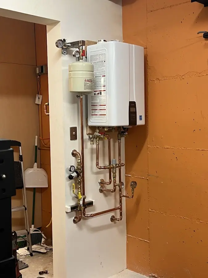 Plumbing technician inspecting water heater connections in Jefferson